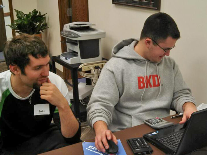 Volunteer sitting next to taxpayer, providing assistance with tax questions